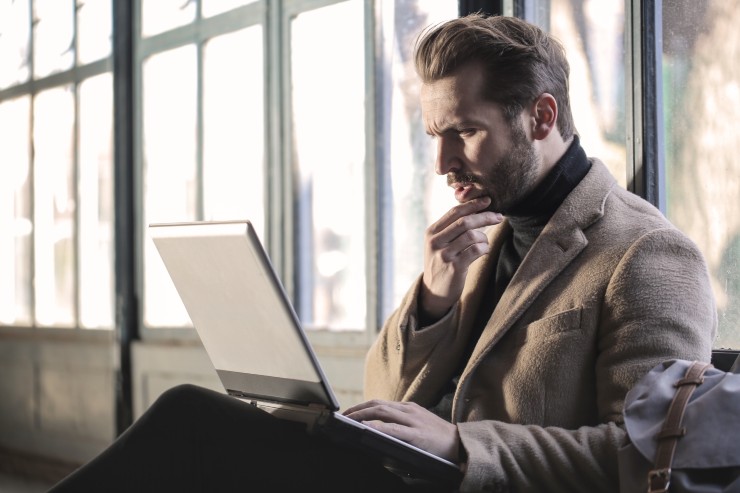 A man with a laptop thinking about his projects